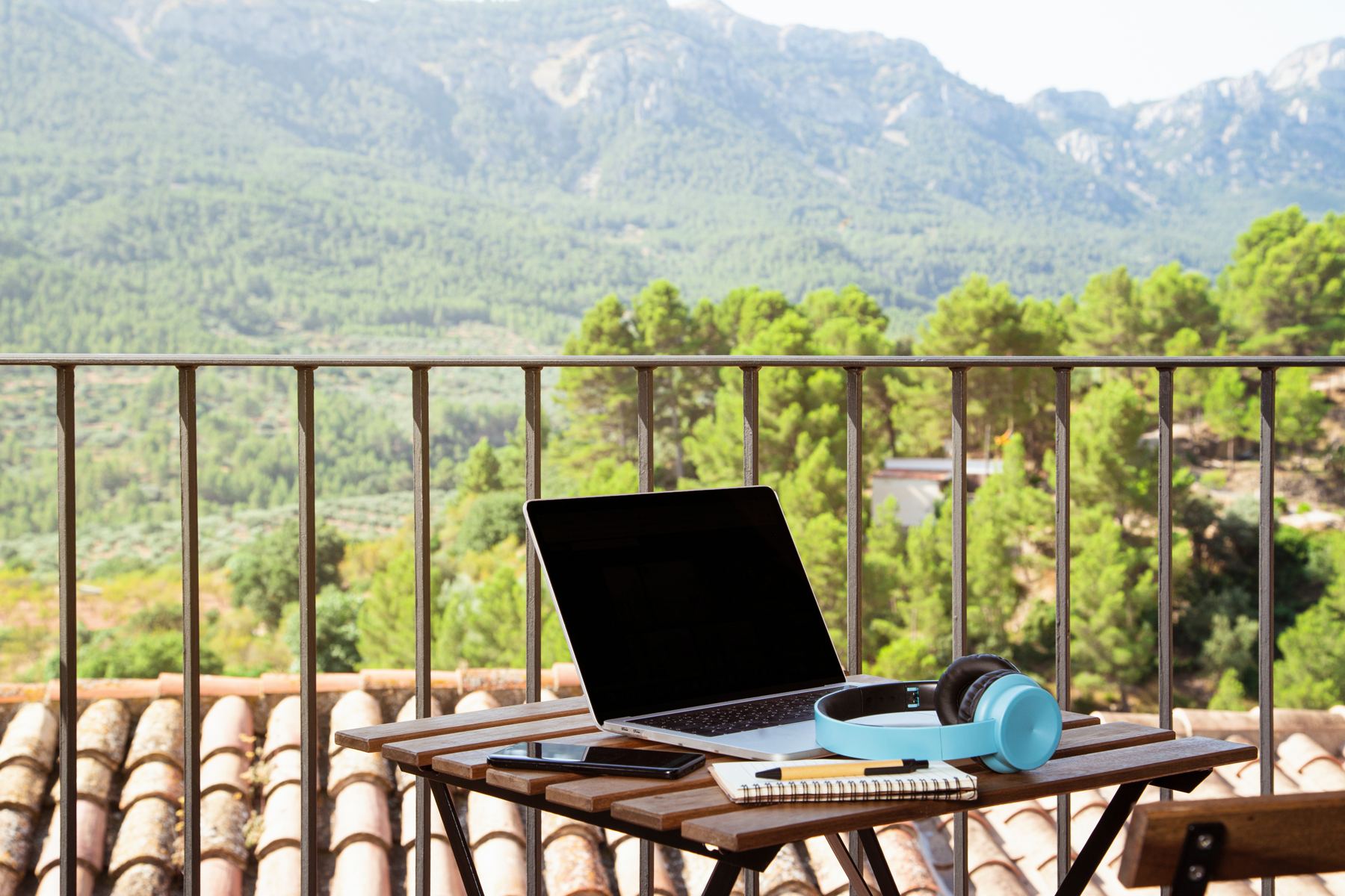 Laptop on a balcony table overlooking mountains